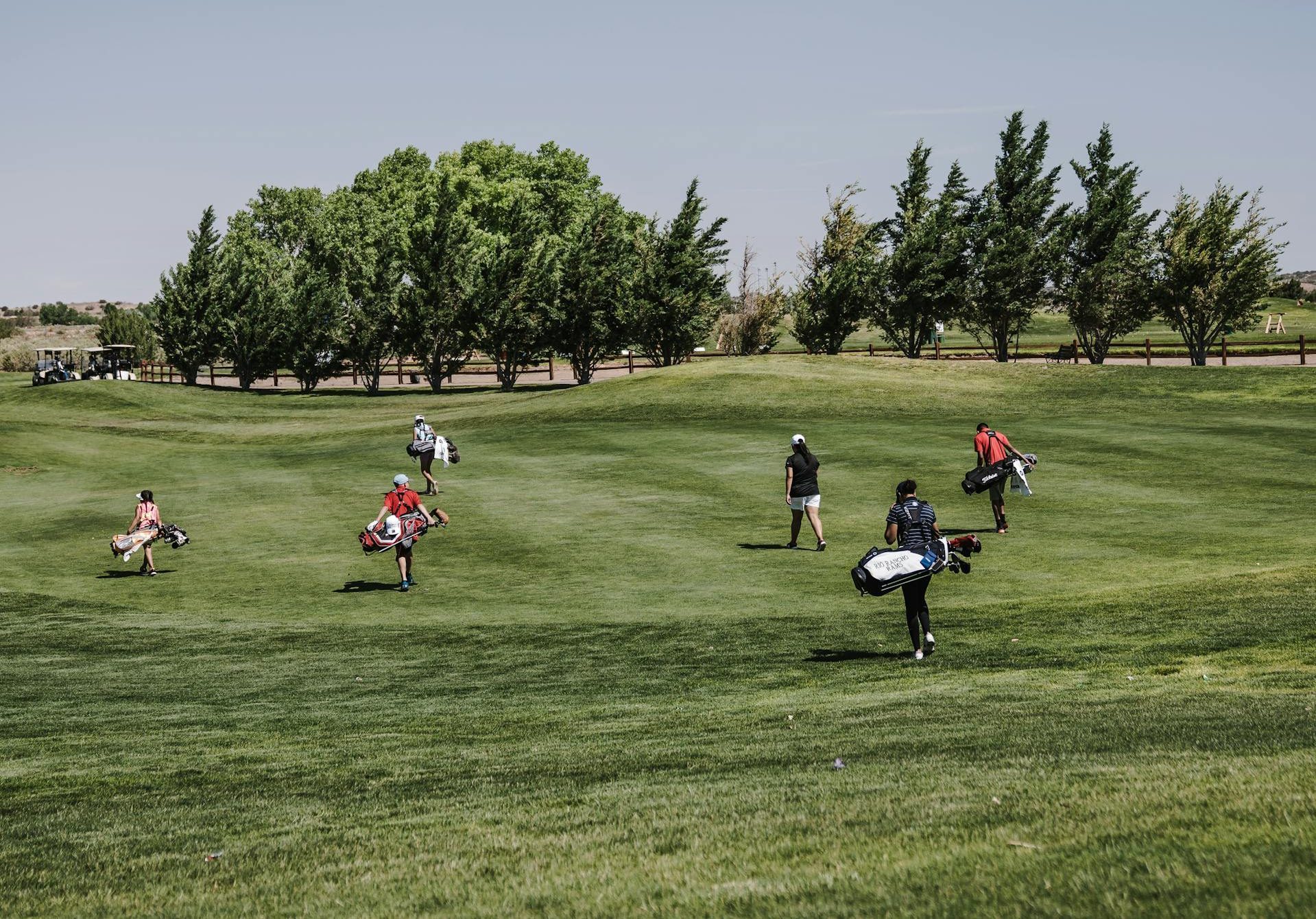 People walking along a golf course.