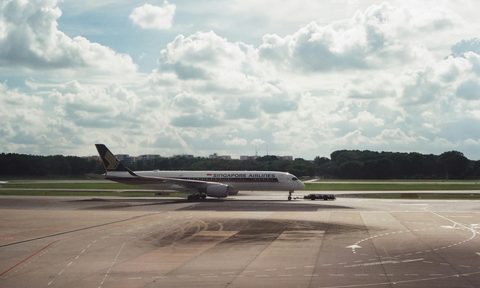 An airplane on the runway under a cloudy sky