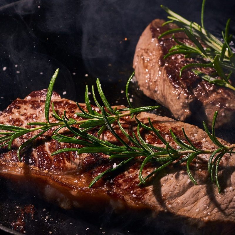 Steak in pan with rosemary
