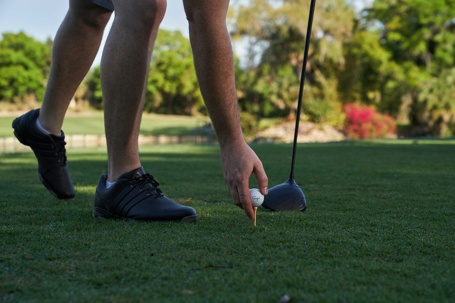 Person setting up their shot on a golf course.
