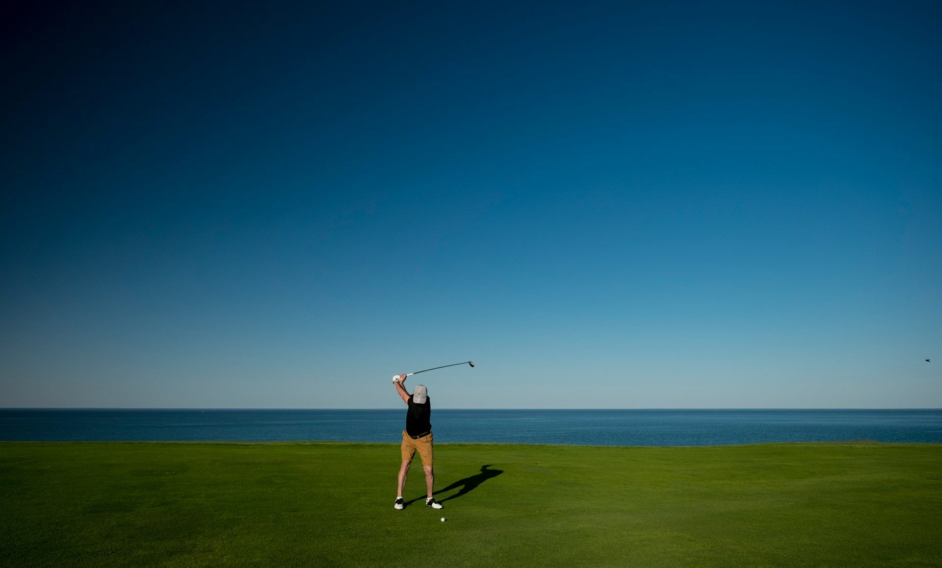 A golfer swinging on the Whistling Straights golf course.