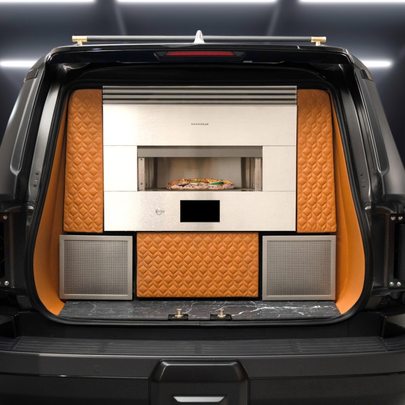 2024 Lexus Monogram GX concept vehicle rear view with doors open revealing pizza oven and bar.