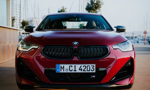 2025 BMW 2 Series Coupe direct front view parked in a yacht club with docking in the background.