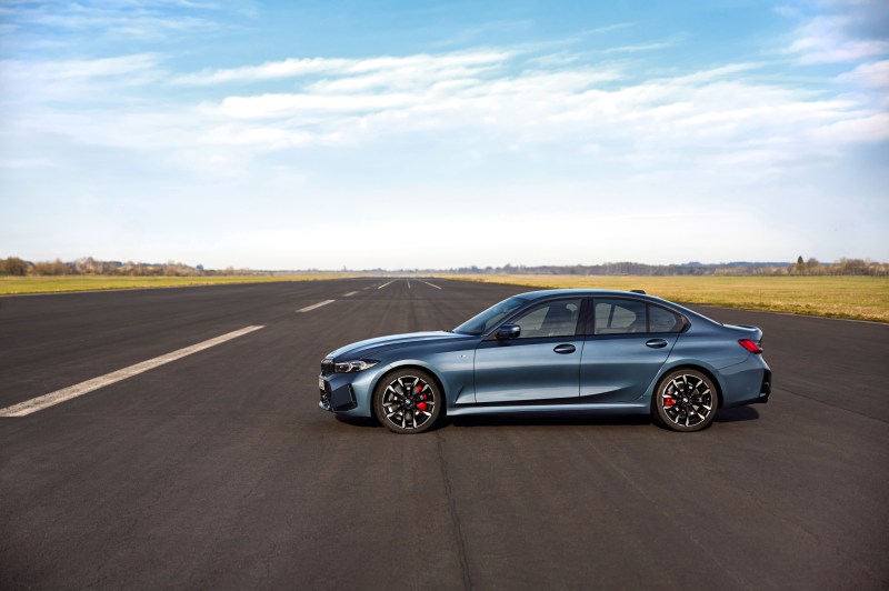 2025 BMW 3 Series left profile shot parked perpendicularly to an airport runway.