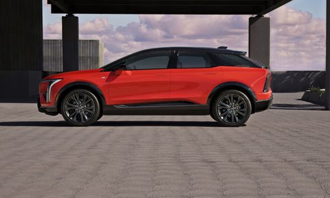 2025 Cadillac Optiq left side profile view parked on a concrete rooftop of a contemporary building.