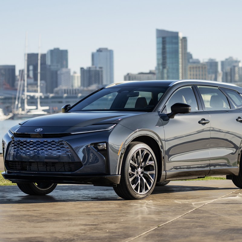 2025 Toyota Crown Signia Limited with Storm Cloud exterior parked on a wet stone parking area with river and cityscape in the background