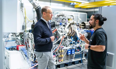 Audi Formula Racing GmbH CTO Stefan Dreyer talking with an engineer at one of th Audi Power Unit test benches.