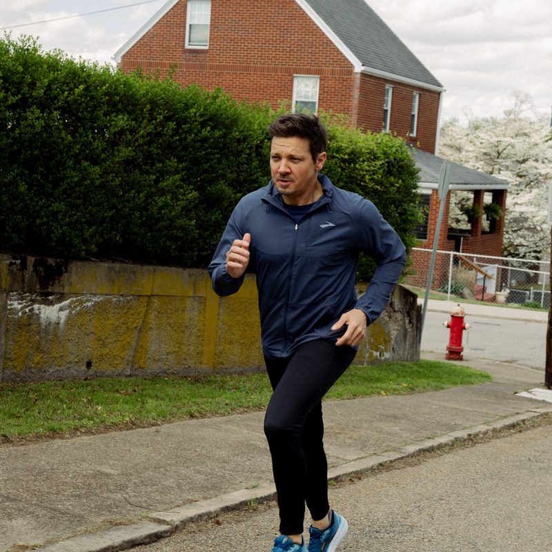 Brooks Running Jeremy Renner Actor running with Brooks running shoes outside on road recovery