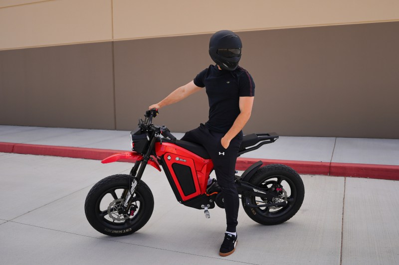 Rider sitting on a Solar Eclipse Race Edition electric motorcycle looking back