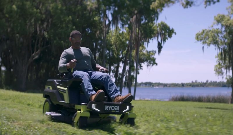 A man using the Ryobi 80V 30-inch zero turn riding mower on his lawn.