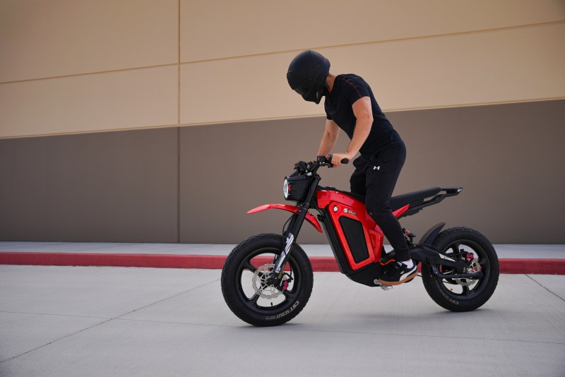 Solar Eclipse Race Edition electric motorcycle with a rider balancing on the pegs fully stopped