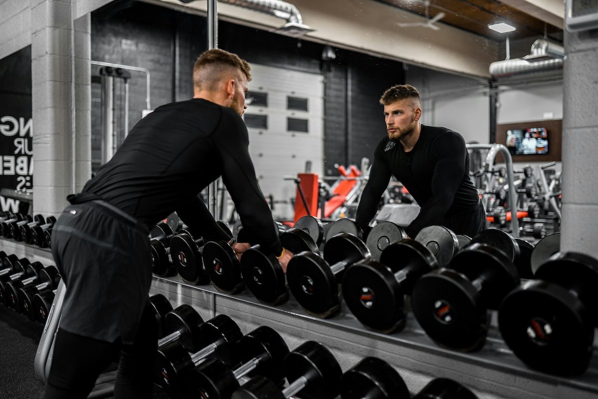 man standing in front of rack of weights