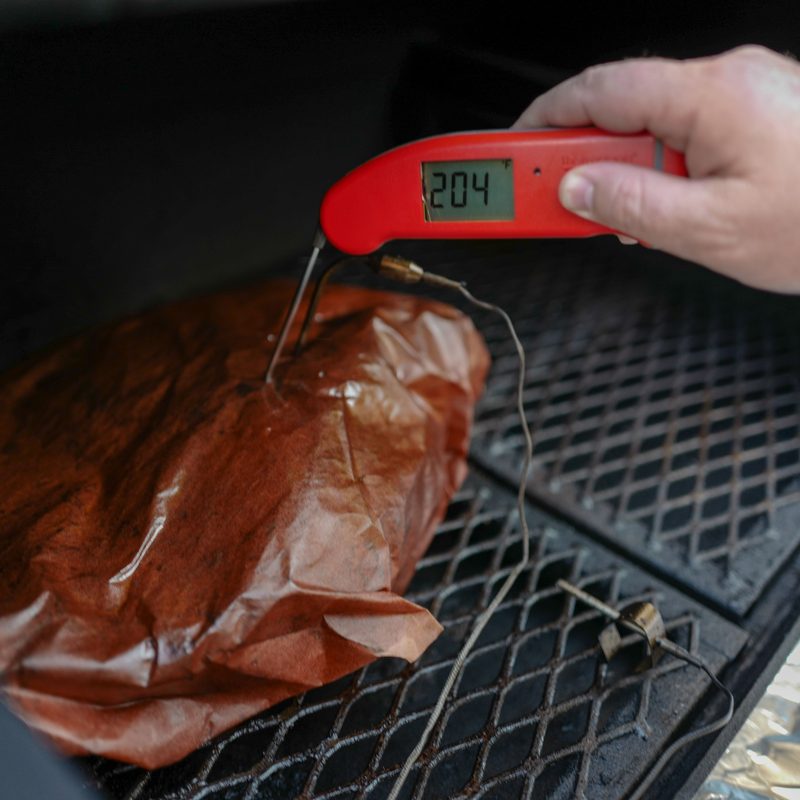 smoked brisket wrapped in butcher paper on the smoker.