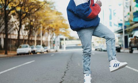 man wearing Adidas Superstar sneakers in blue