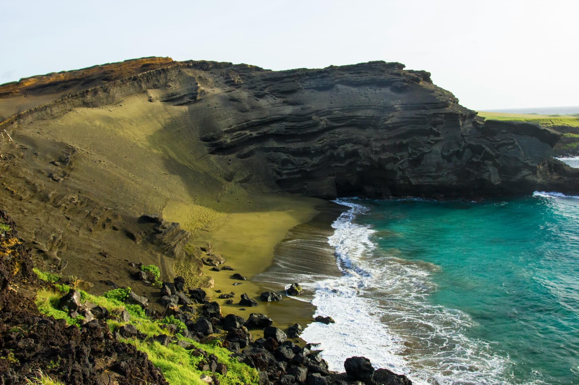 a rocky cliff next to a body of water