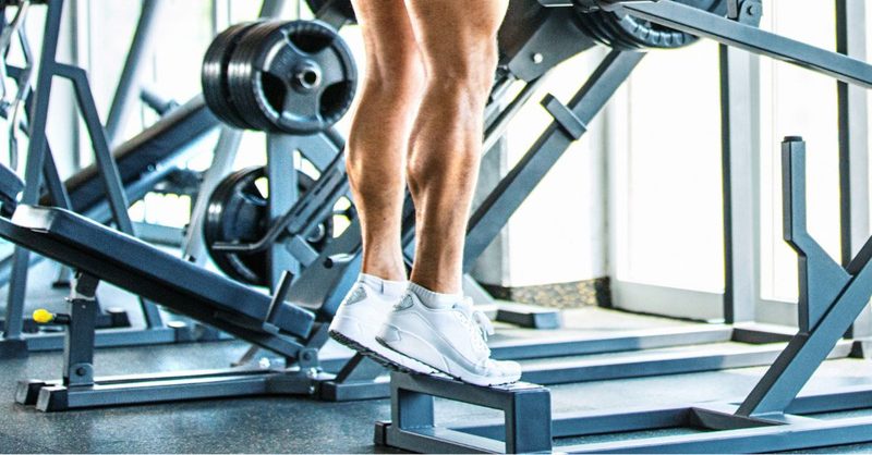 Man doing calf raises in the gym step