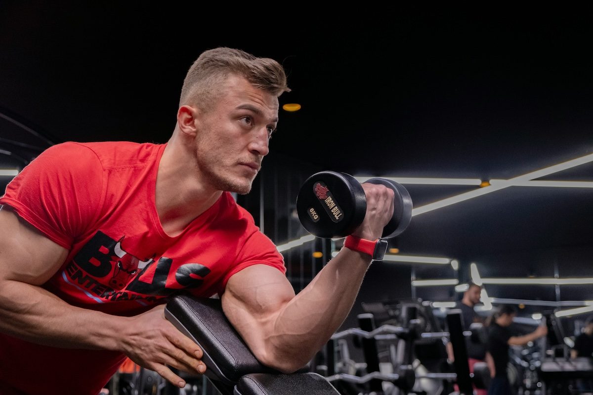 man doing curls with red shirt