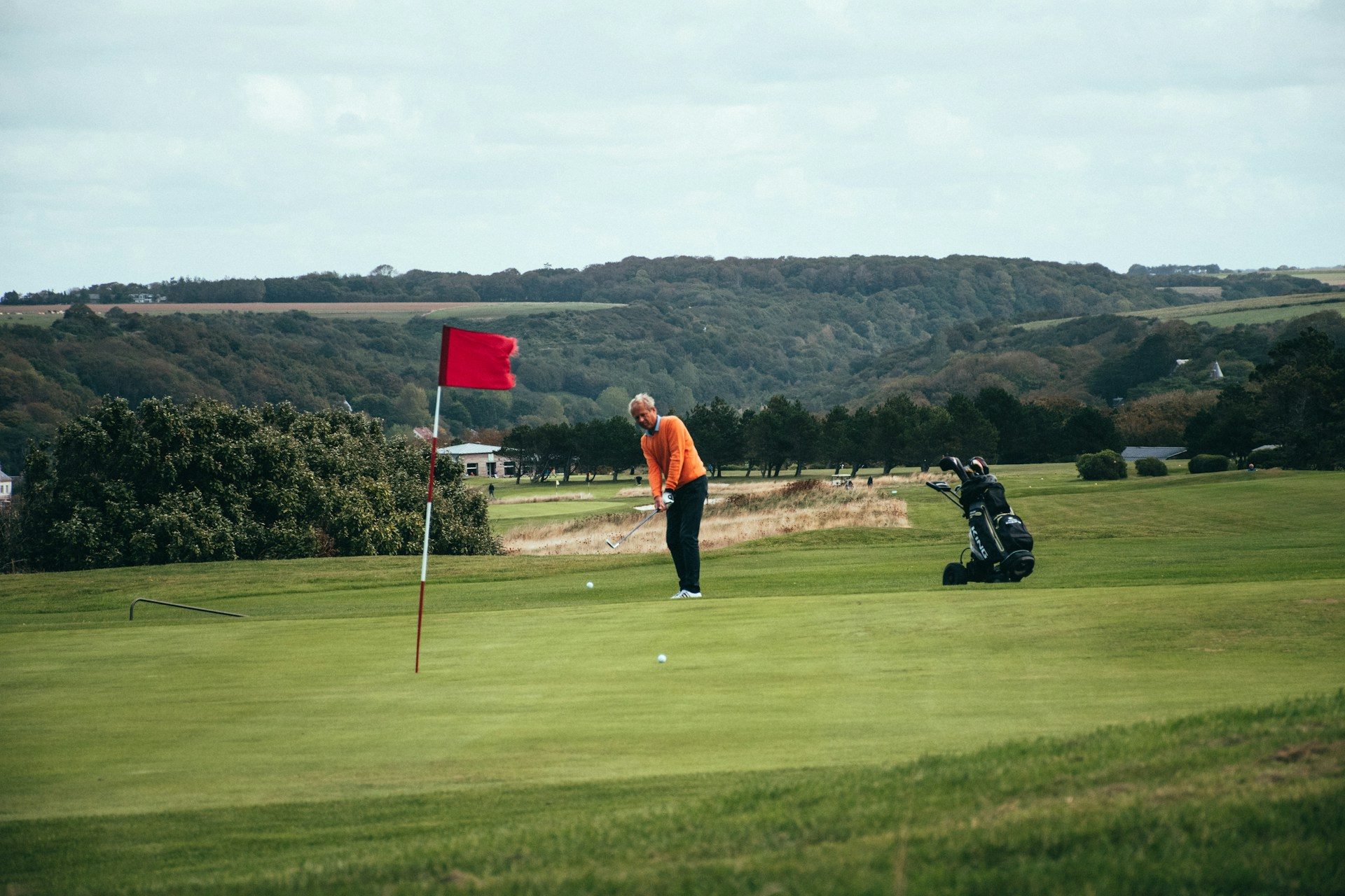 A person about to swing on the golf course.