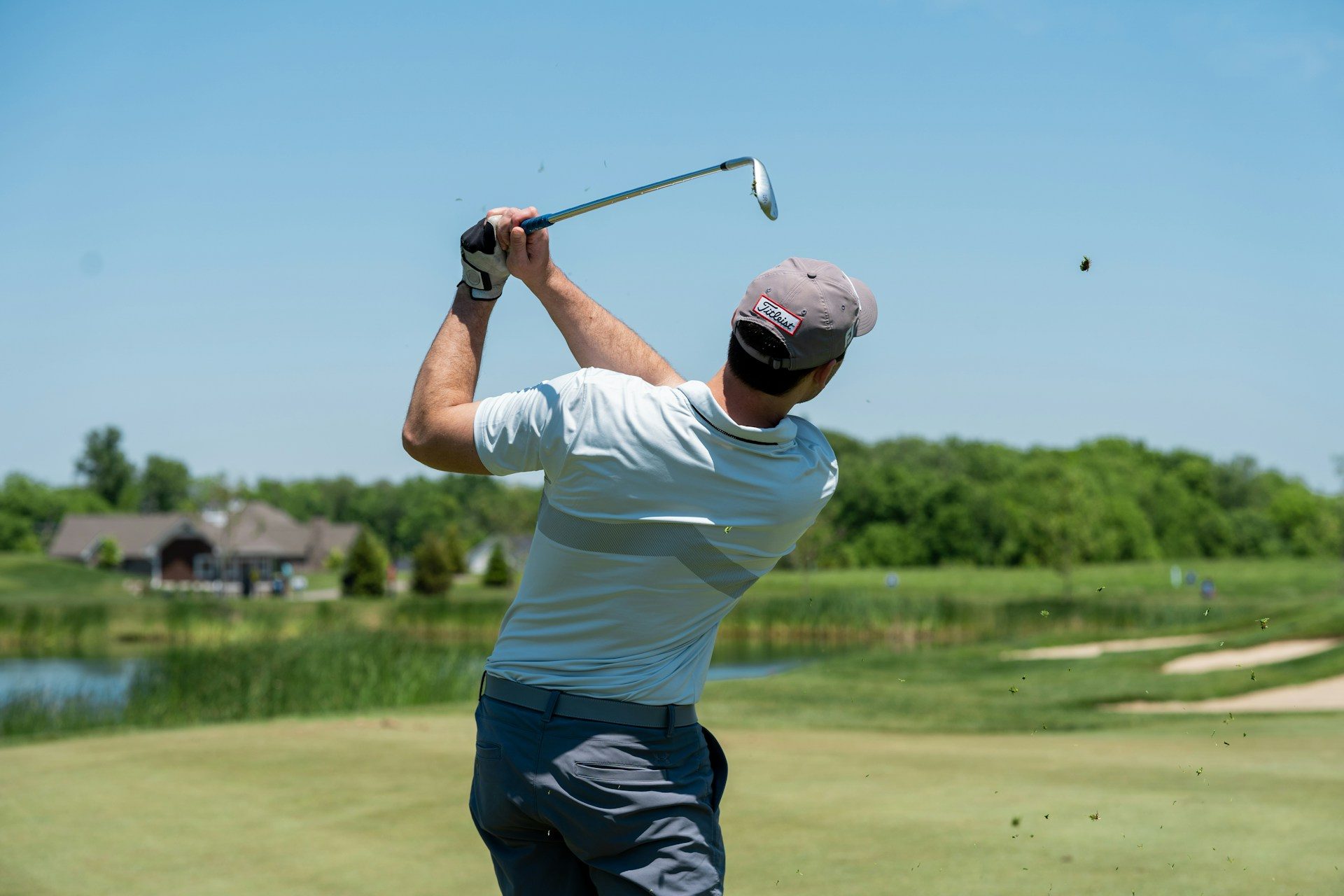A person swinging a club on the golf course.