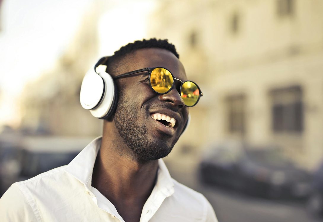man wearing round sunglasses and headphones