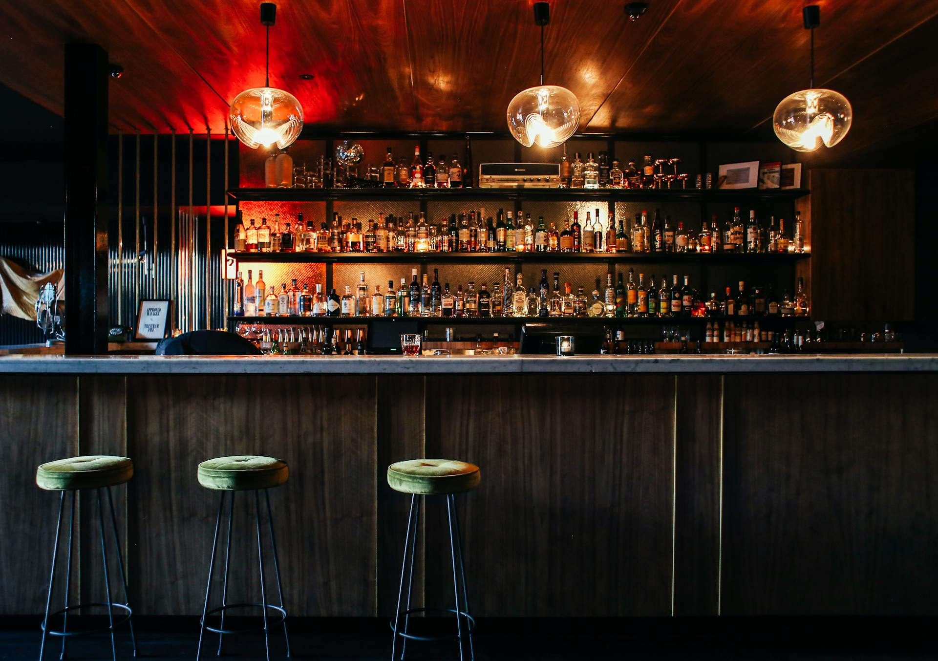 Dark bar with three empty barstools