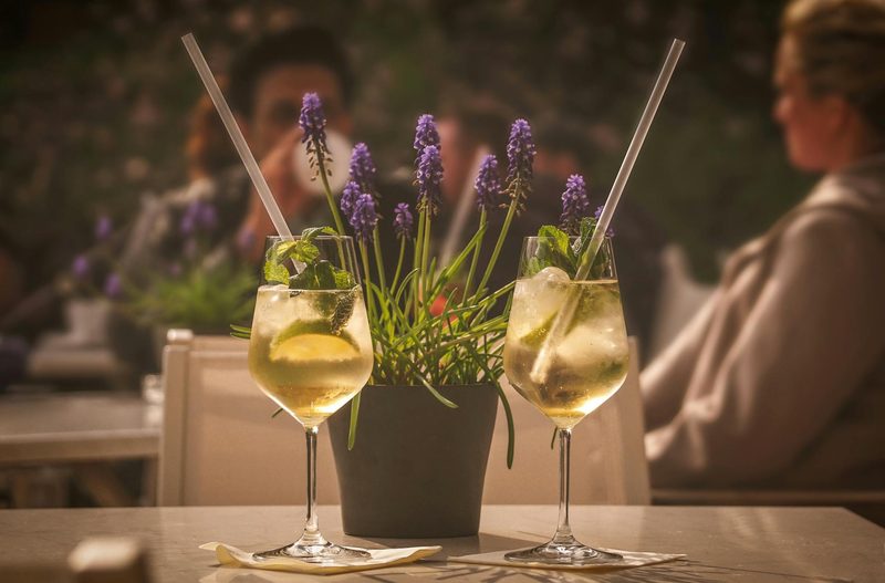 Two wine glasses with drinks and straws