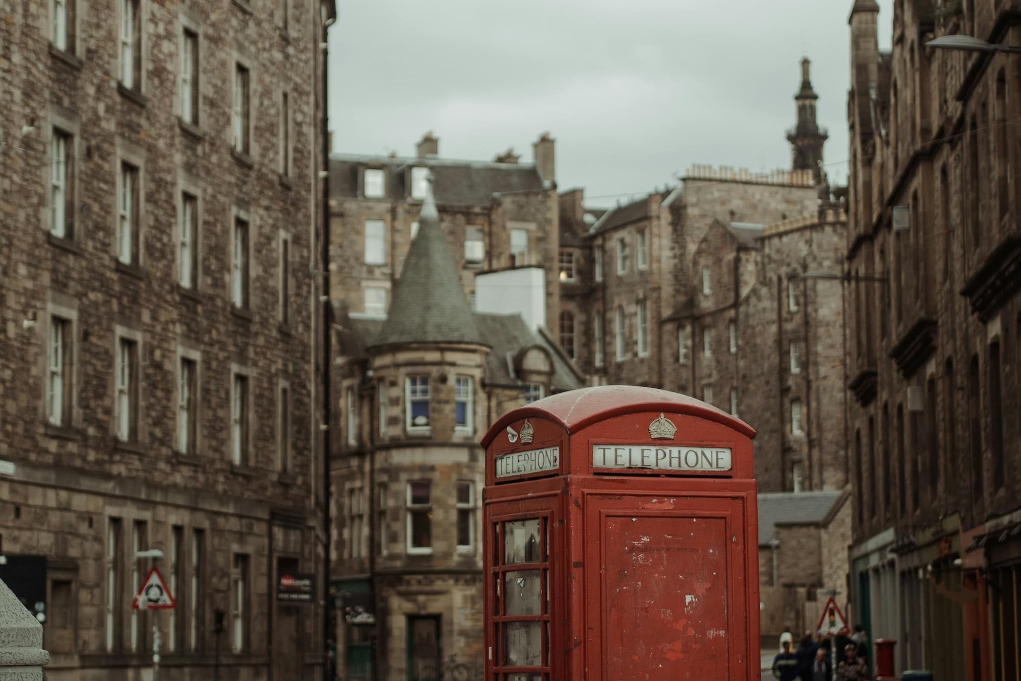 red telephone booth in front of old buildings in scotland