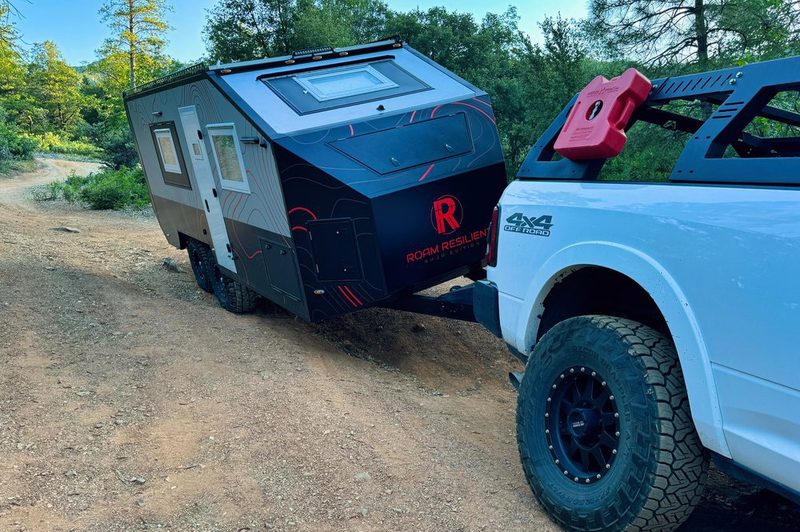Front of Roam Resilient's Baja Overland travel trailer being towed by a pickup truck.