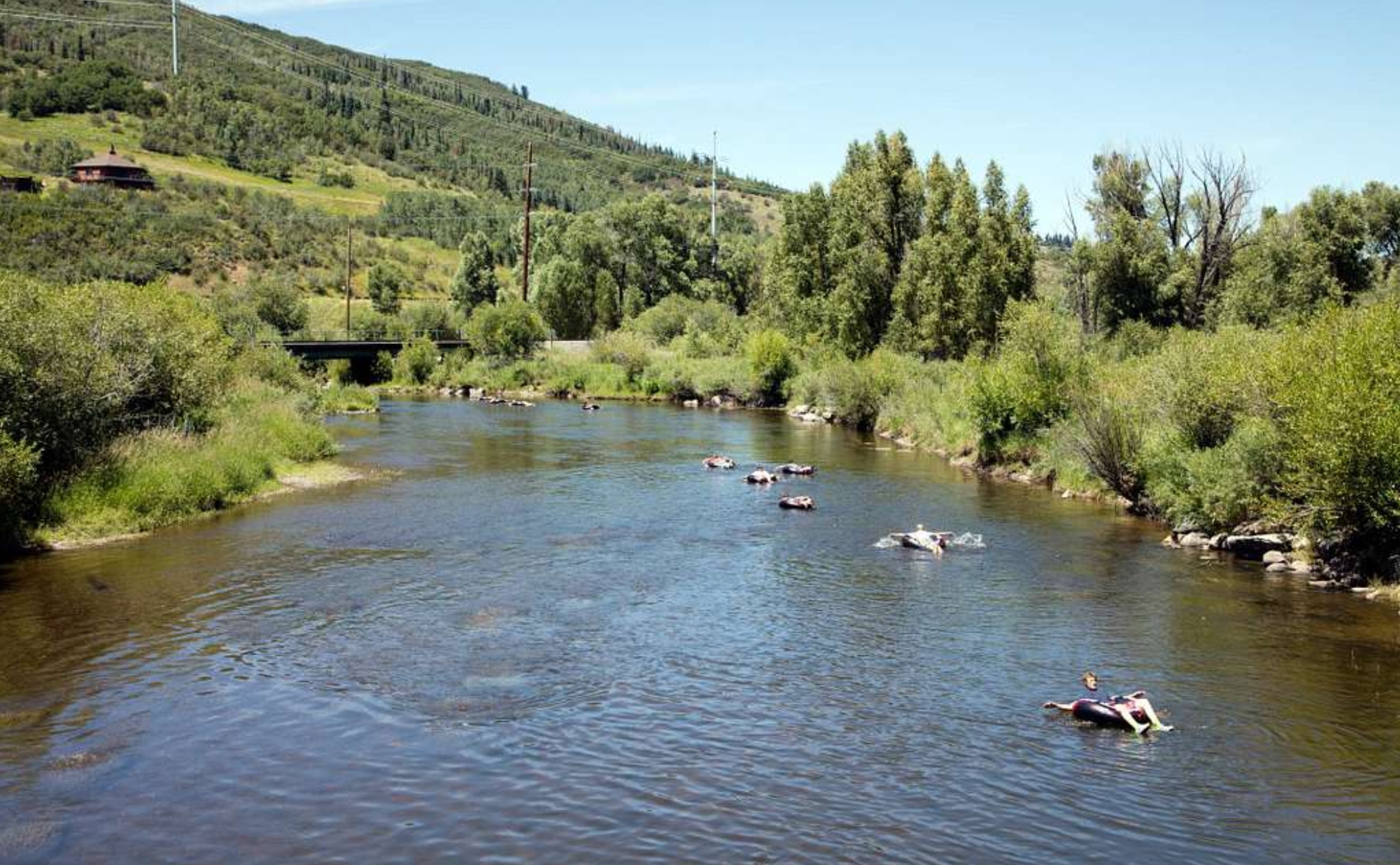 a group of people floating along Yampa River on a clear day