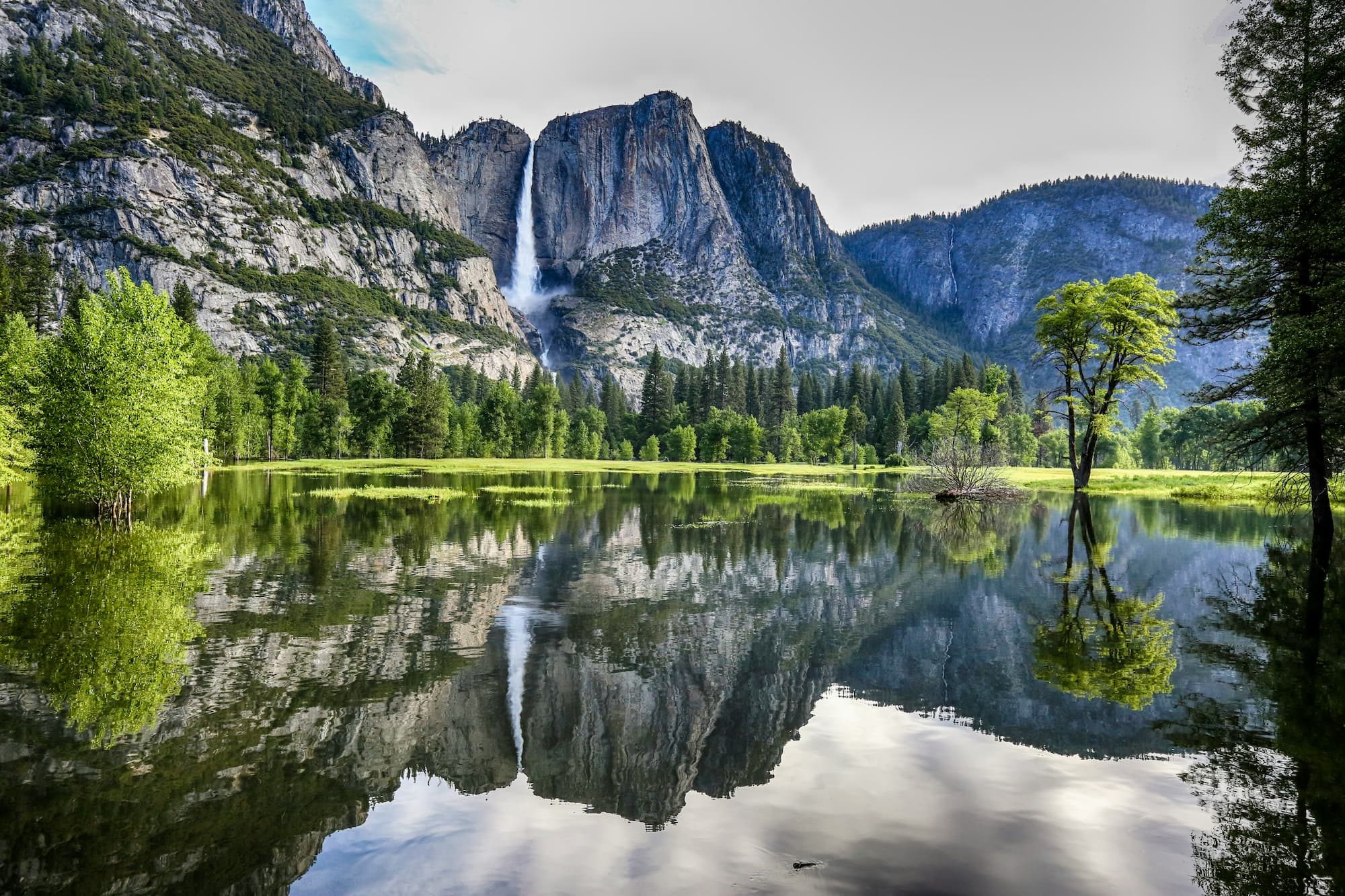 mountain and waterfall near lake