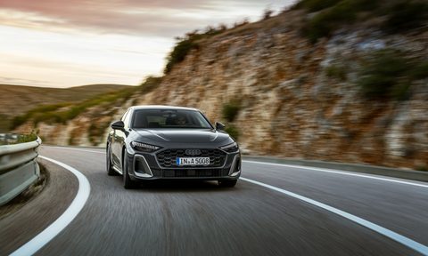2025 Audi A5 right front frontal view driving on a highway in the mountains.