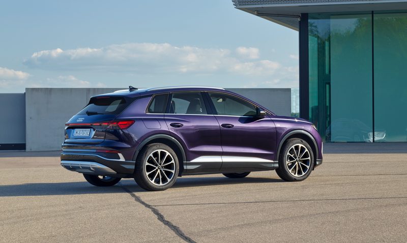 2025 Audi Q4 35 e-tron parked on a rooftop area with concrete wall and blue sky in the background rear right three-quarter view.