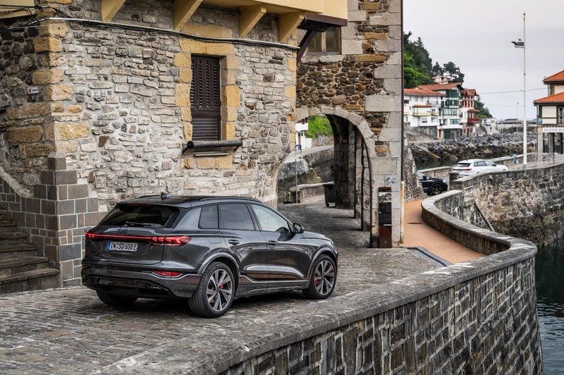2025 Audi SQ6 e-tron European model parked on a stone street near a seaport.