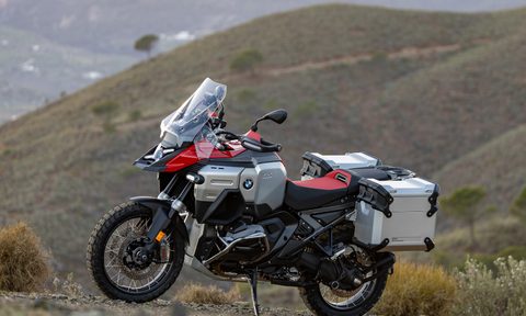 2025 BMW R 1300 GS Adventure parked on a hillside with mountains in the background.