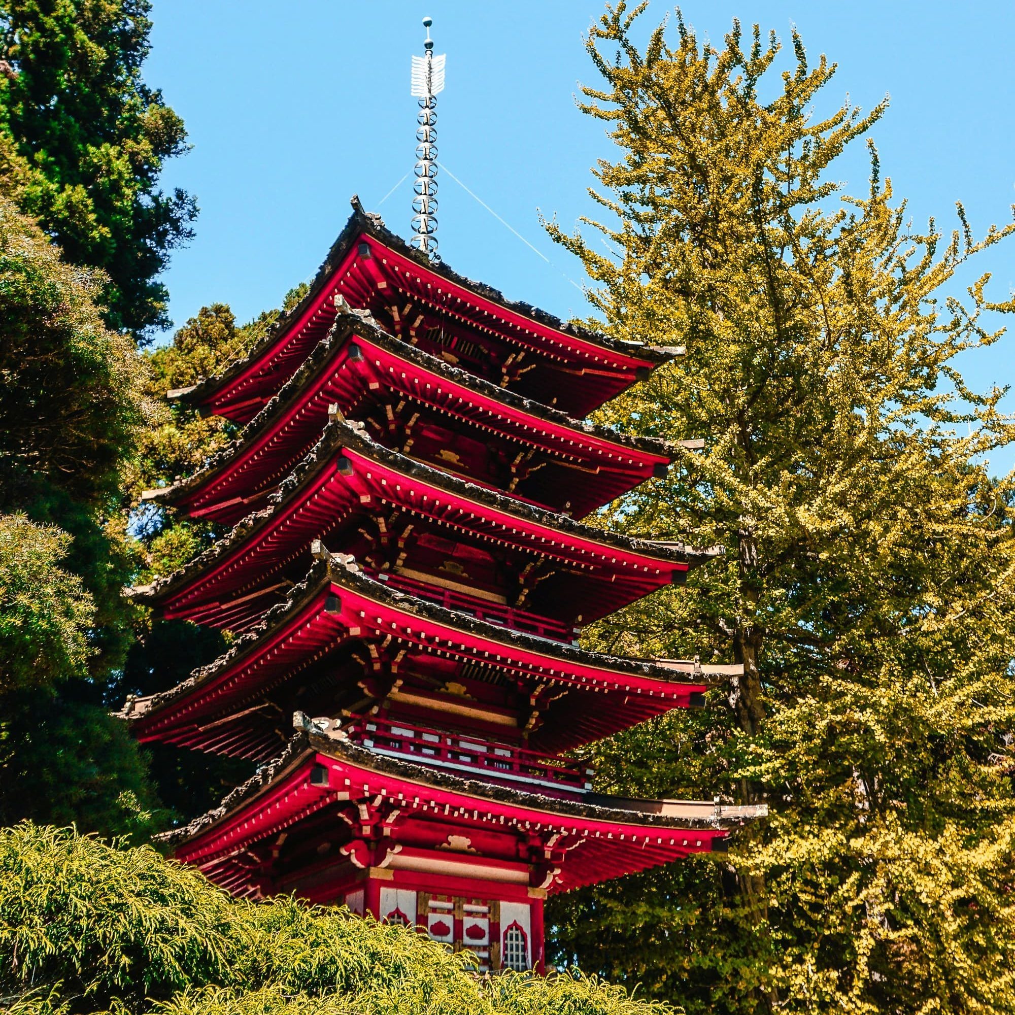 red and green multi-layer pagoda temple under blue sky