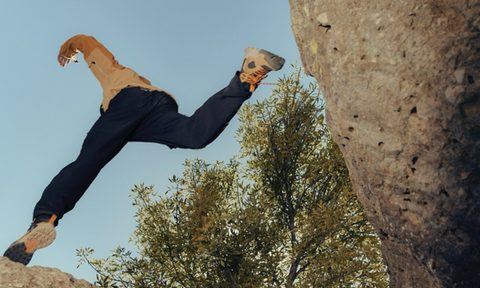 Hiking boots jumping over gap in rocks
