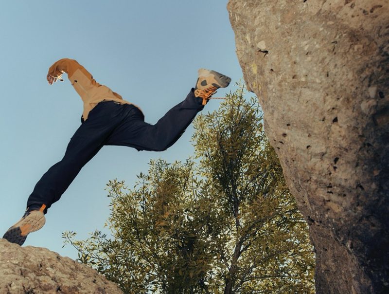 Hiking boots jumping over gap in rocks