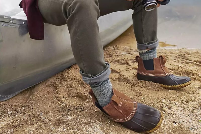 A man wearing the L.L. Bean Men's Chelsea Bean 6.5 in Boots by the lake.