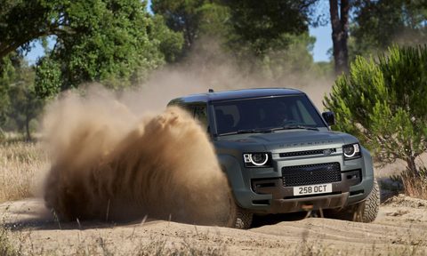 Land Rover Defender OCTA driving through deep sand.