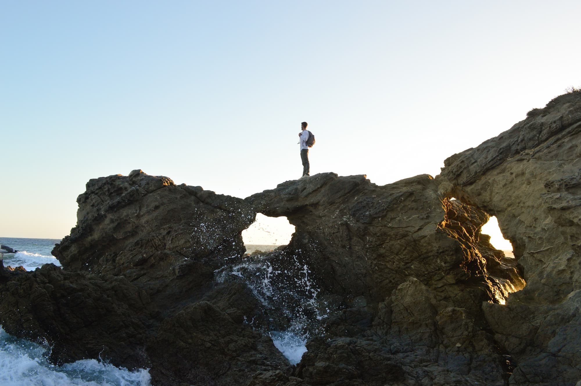 person standing on rocks in ocean