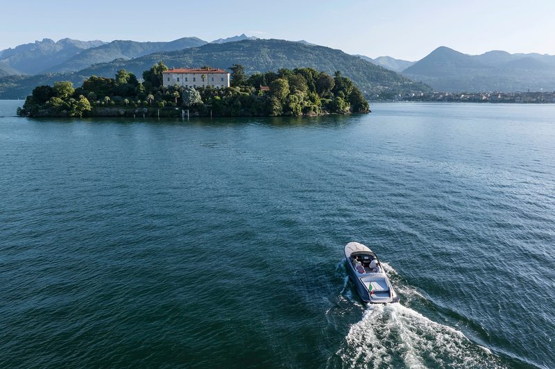 Maserati TRIDENTE luxury all-electric powerboat crossing Lake Maggiore to a hotel on an island.