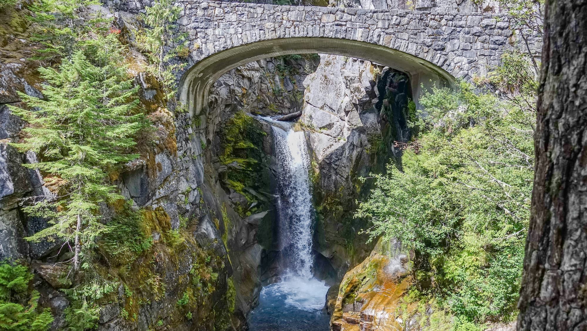 gray concrete bridge over waterfall outside