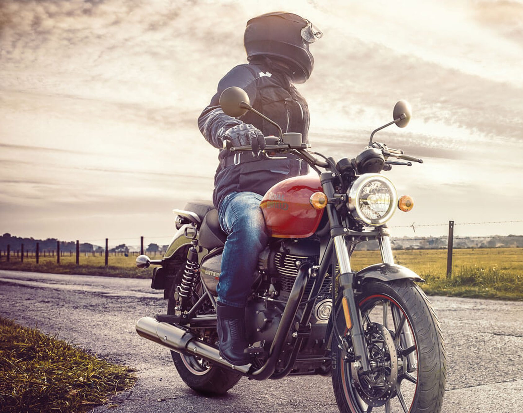 Royal Enfield Meteor 350 with a red tank driver looking left.