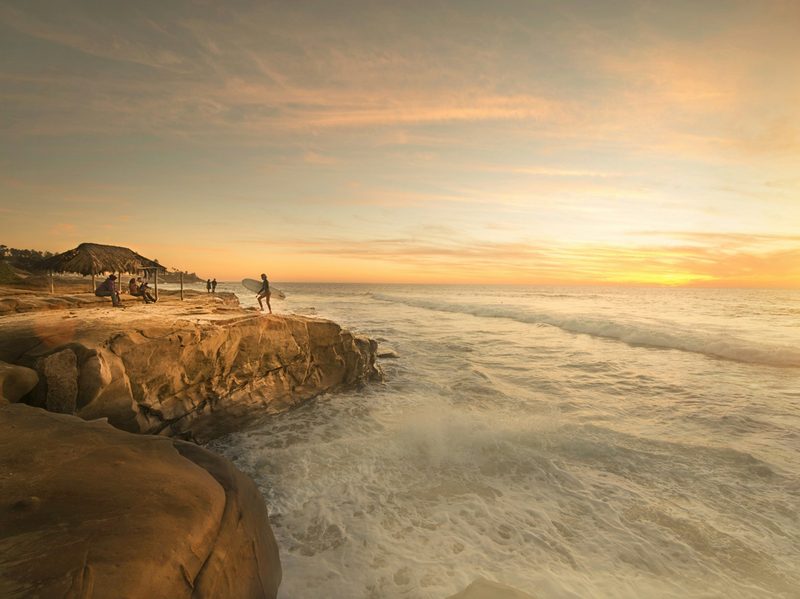Surfer on cliffs, California
