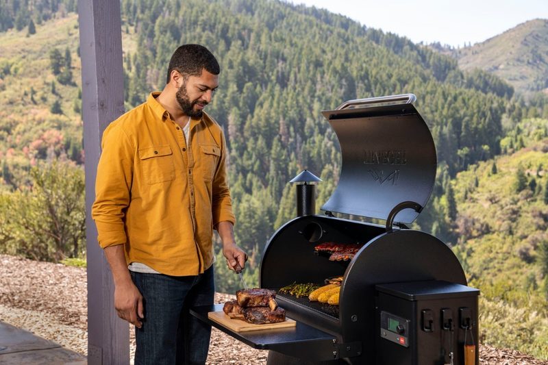 A man tends a Traeger Pro 780 grill.