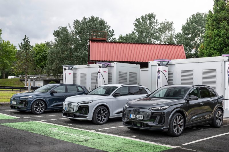 Two 2025 Audi Q6 e-trons and a 2025 Audi SQ6 e-tron plugged in at a DC fast-charging station.