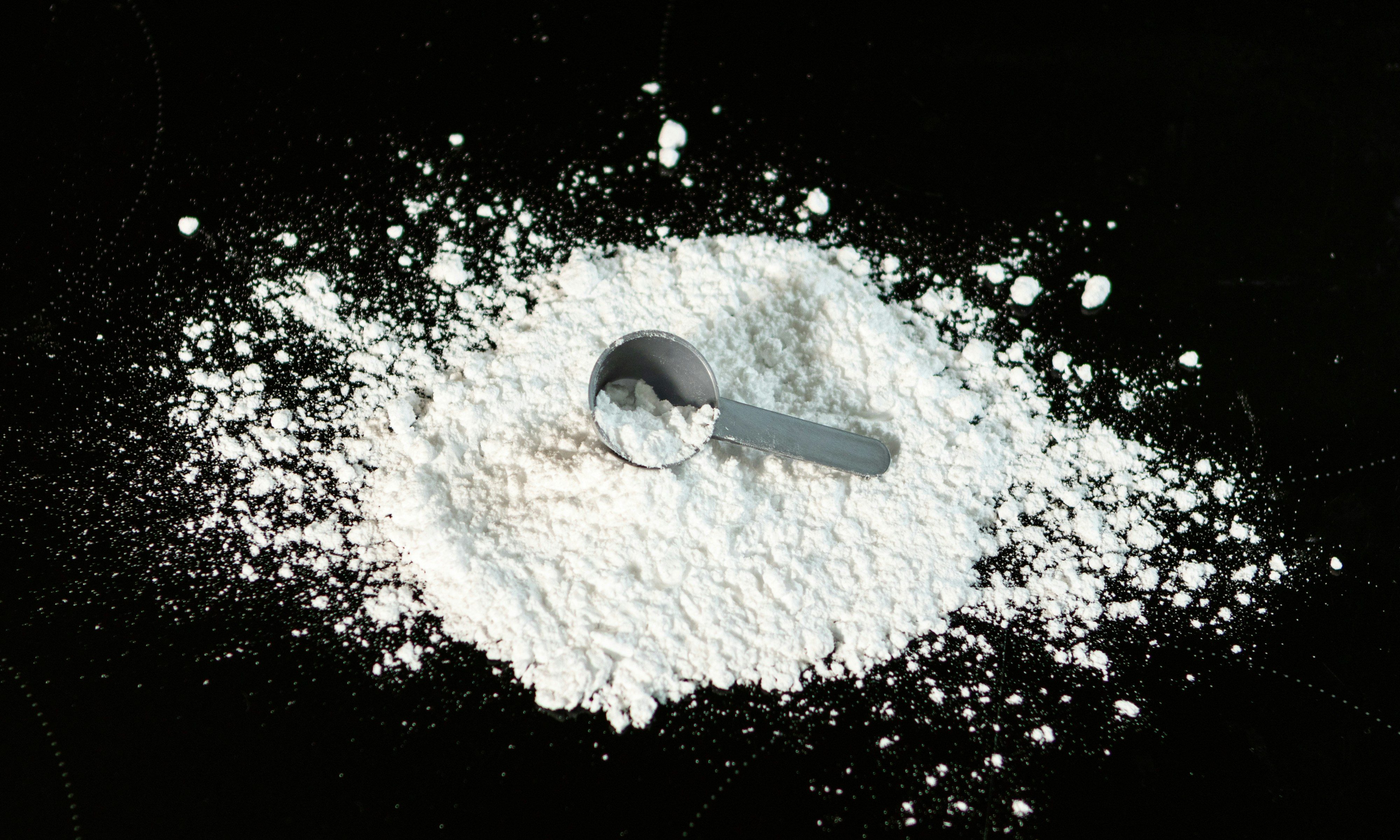 Spilled creatine with a scoop spoon