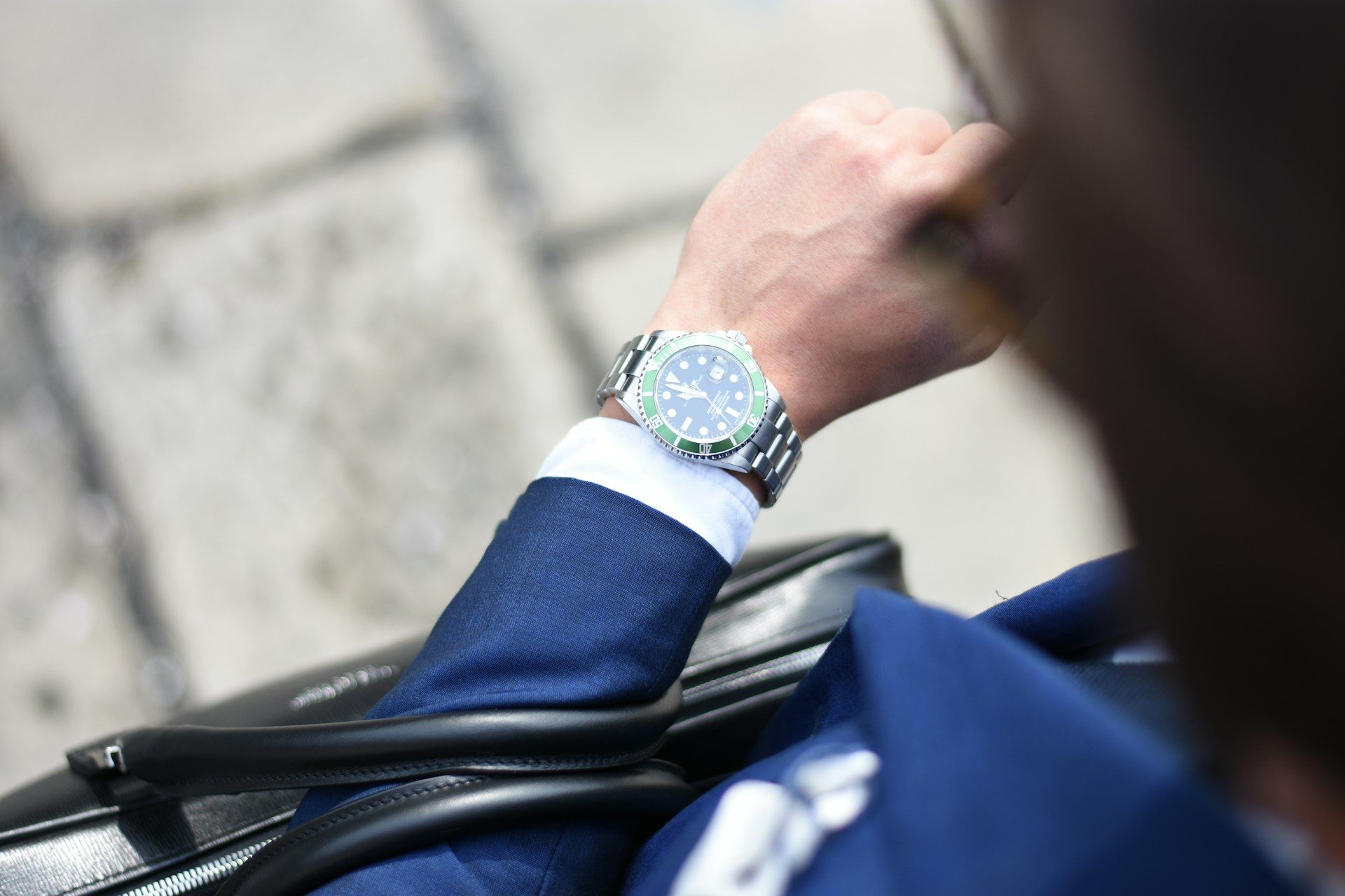 Man looking down at silver watch