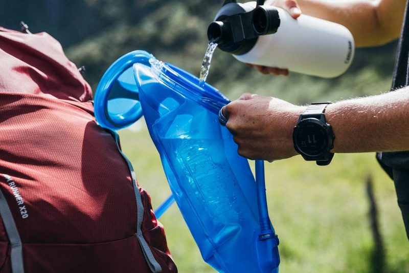 Man pouring water into a CamelBak hydration bladder/reservoir.