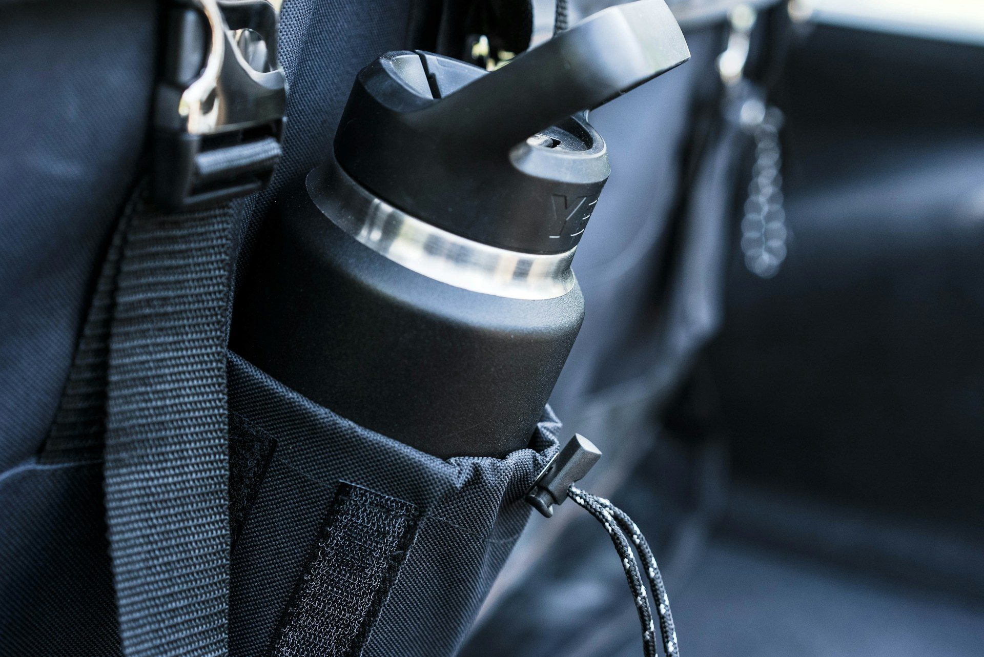 a yeti water bottle in the side pocket of a black bag